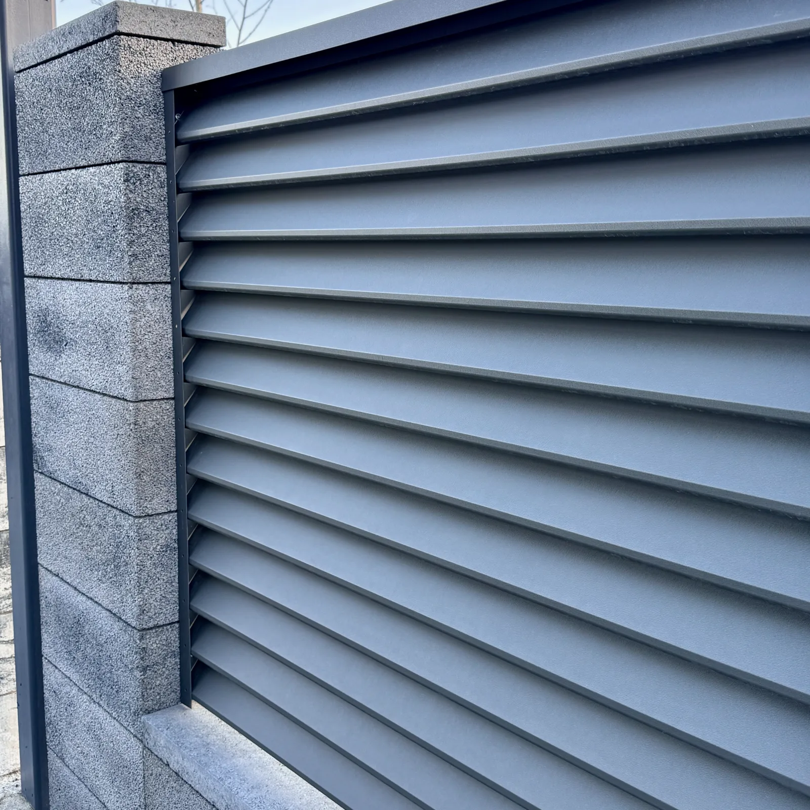 Sigma louvre fence fitted between masonry pillars